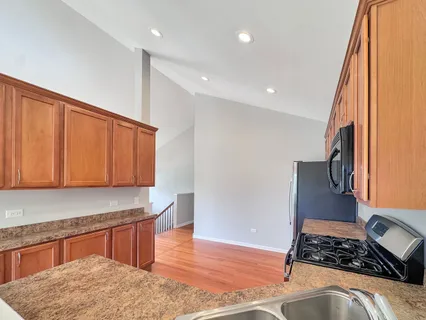 a kitchen with stainless steel appliances granite countertop a stove a sink and a refrigerator