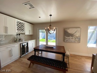 2712 Rialto Road Las Vegas, NV 89108 - Photo 15 of 54 Dining room with wine cooler, a bar, a chandelier, and light wood-style floors