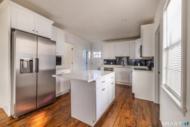 a kitchen with white cabinets and stainless steel appliances