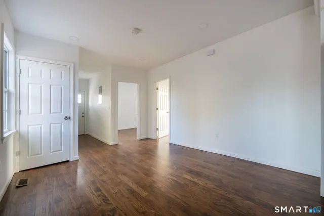 a view of an empty room with wooden floor