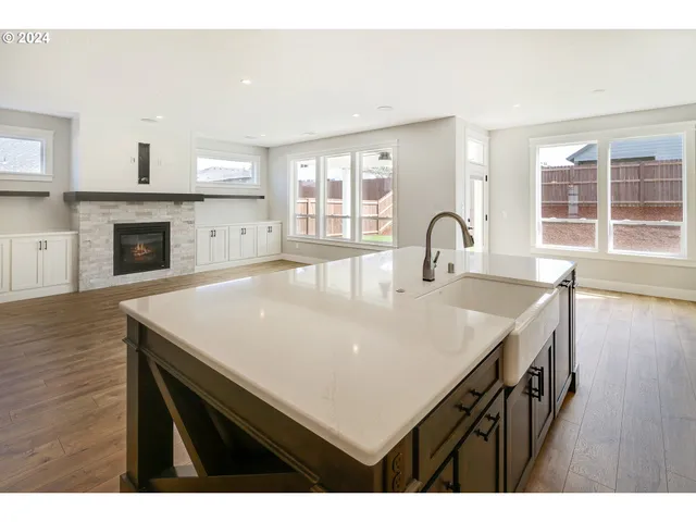 a view of kitchen island with sink wooden floor and living room