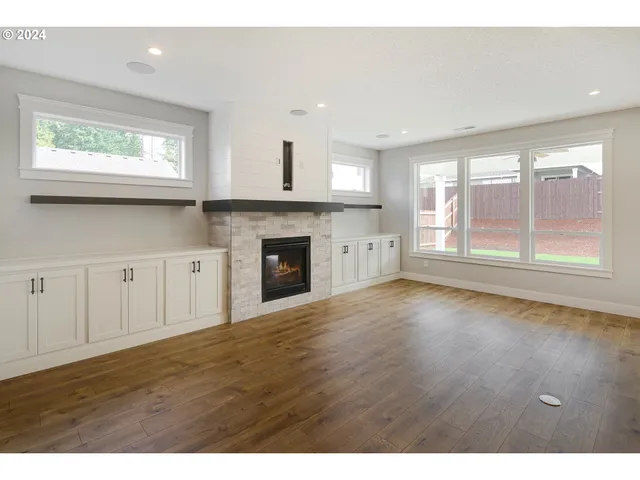 a view of empty room with wooden floor and fireplace