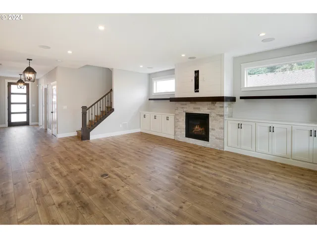 a view of empty room with kitchen and fireplace