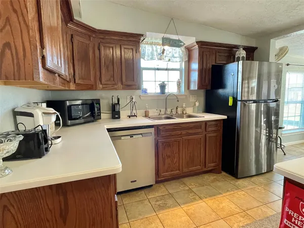 a kitchen with a sink a refrigerator and cabinets