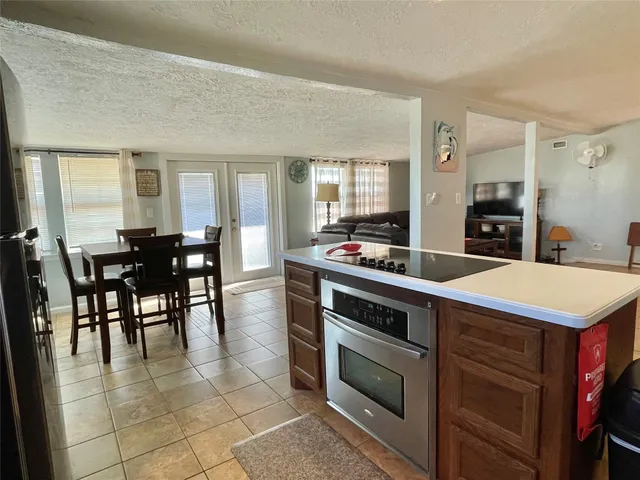 a kitchen with a stove a sink dishwasher and a dining table with chairs