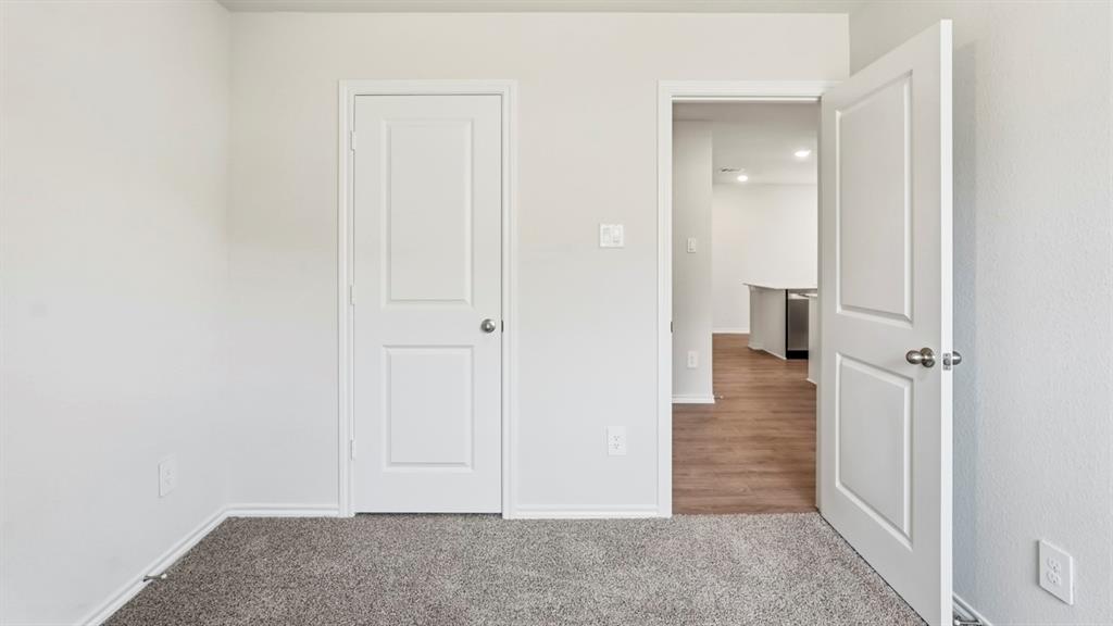 3535 Spring Time Street Forney, TX 75126 - Photo 21 of 23 Interior room featuring light gray walls and dark gray carpet