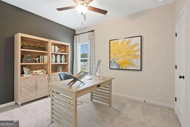 a view of a workspace with furniture and a window