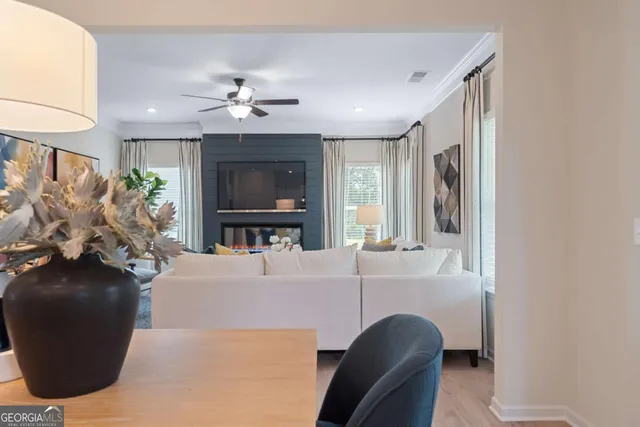 a living room with furniture a flat screen tv and a large window