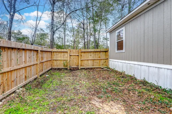 a view of a bedroom with a window and wooden floor
