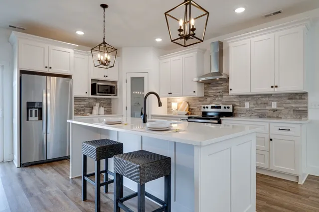 a kitchen with kitchen island granite countertop stainless steel appliances a sink a stove and cabinets