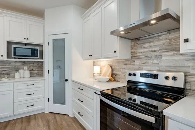 a kitchen with a sink a stove and chairs