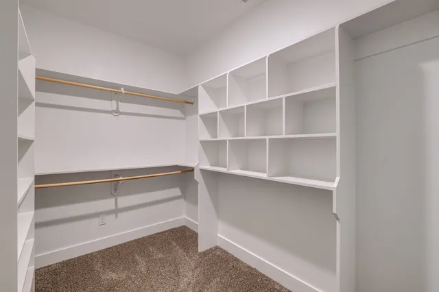 a spacious bedroom with a bed and a refrigerator