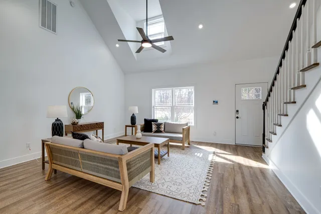 a living room with furniture or couches and a dining table with wooden floor
