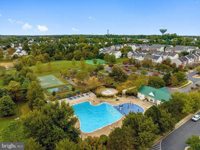 an aerial view of residential houses with outdoor space and trees