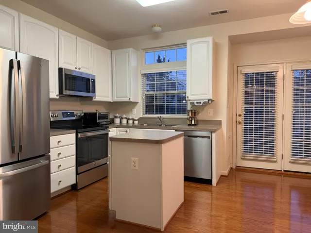 a kitchen with granite countertop a sink stove and refrigerator