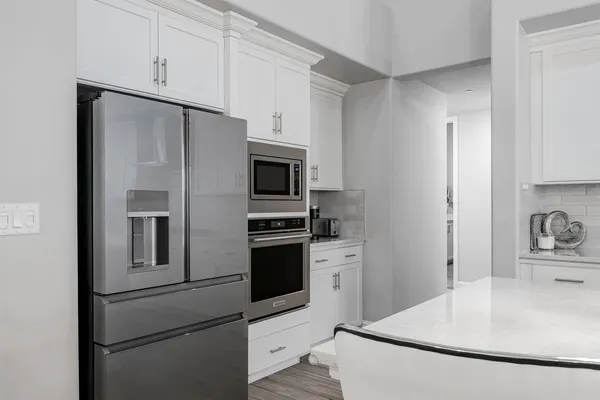 a large kitchen with kitchen island a large island a sink stainless steel appliances and cabinets