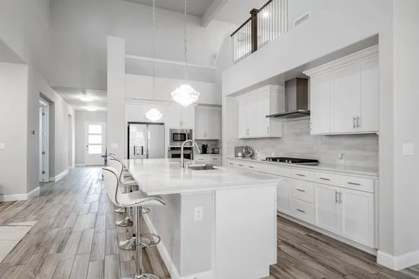 a kitchen with stainless steel appliances kitchen island granite countertop a sink and cabinets