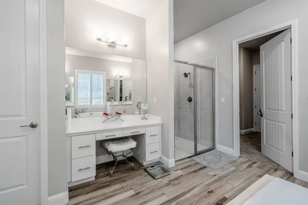 a spacious bathroom with a double vanity sink a mirror and a shower