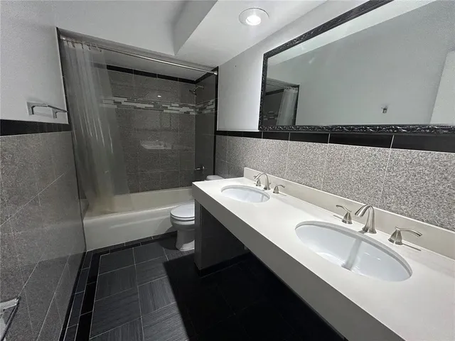 a bathroom with a tub sink toilet and mirror