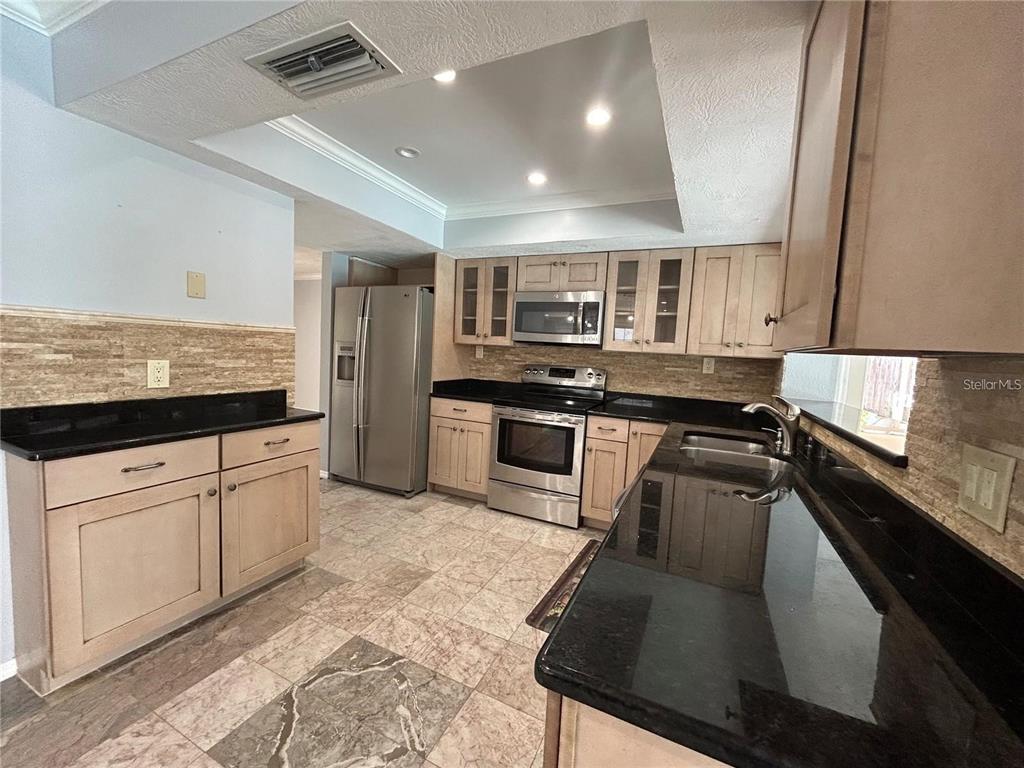 321 Ridgewood Street Altamonte Springs, FL 32701 - Photo 5 of 50 a kitchen with stainless steel appliances granite countertop a stove a sink and a microwave