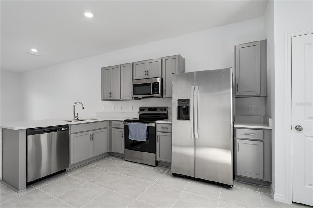 14052 Textile Run Parrish, FL 34219 - Photo 4 of 23 a kitchen with cabinets and stainless steel appliances