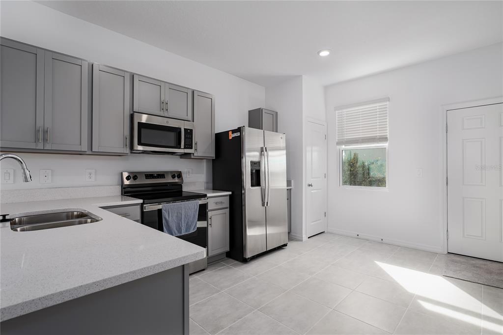 14052 Textile Run Parrish, FL 34219 - Photo 5 of 23 a kitchen with a refrigerator stove and microwave
