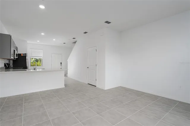 a view of kitchen with refrigerator and window