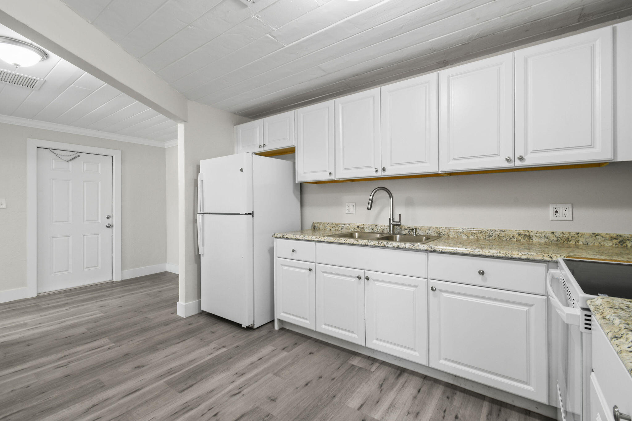1301 West 25th Street Riviera Beach, FL 33404 - Photo 11 of 34 a kitchen with granite countertop white cabinets and refrigerator