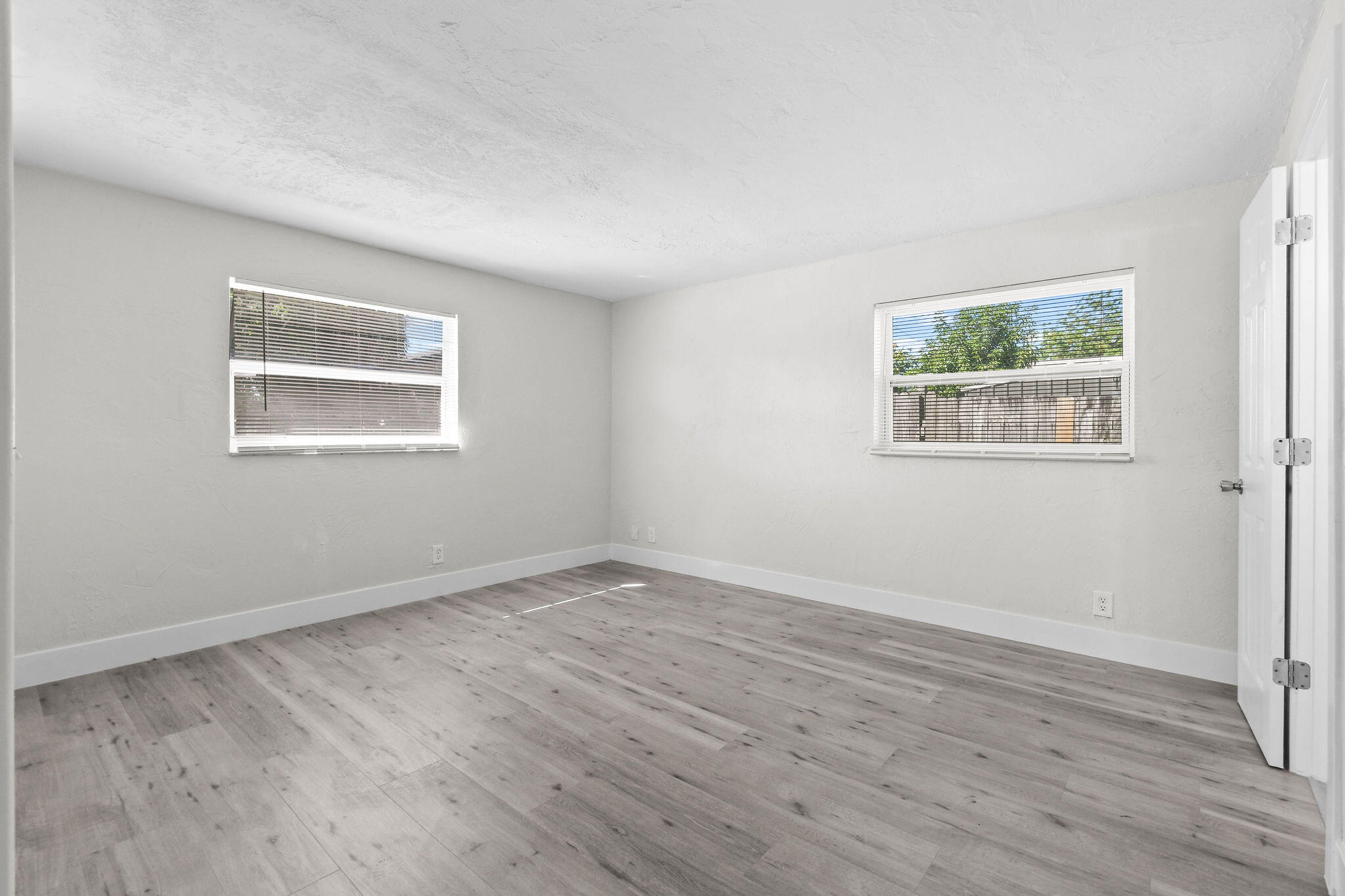 1301 West 25th Street Riviera Beach, FL 33404 - Photo 14 of 34 a view of an empty room with wooden floor and a window