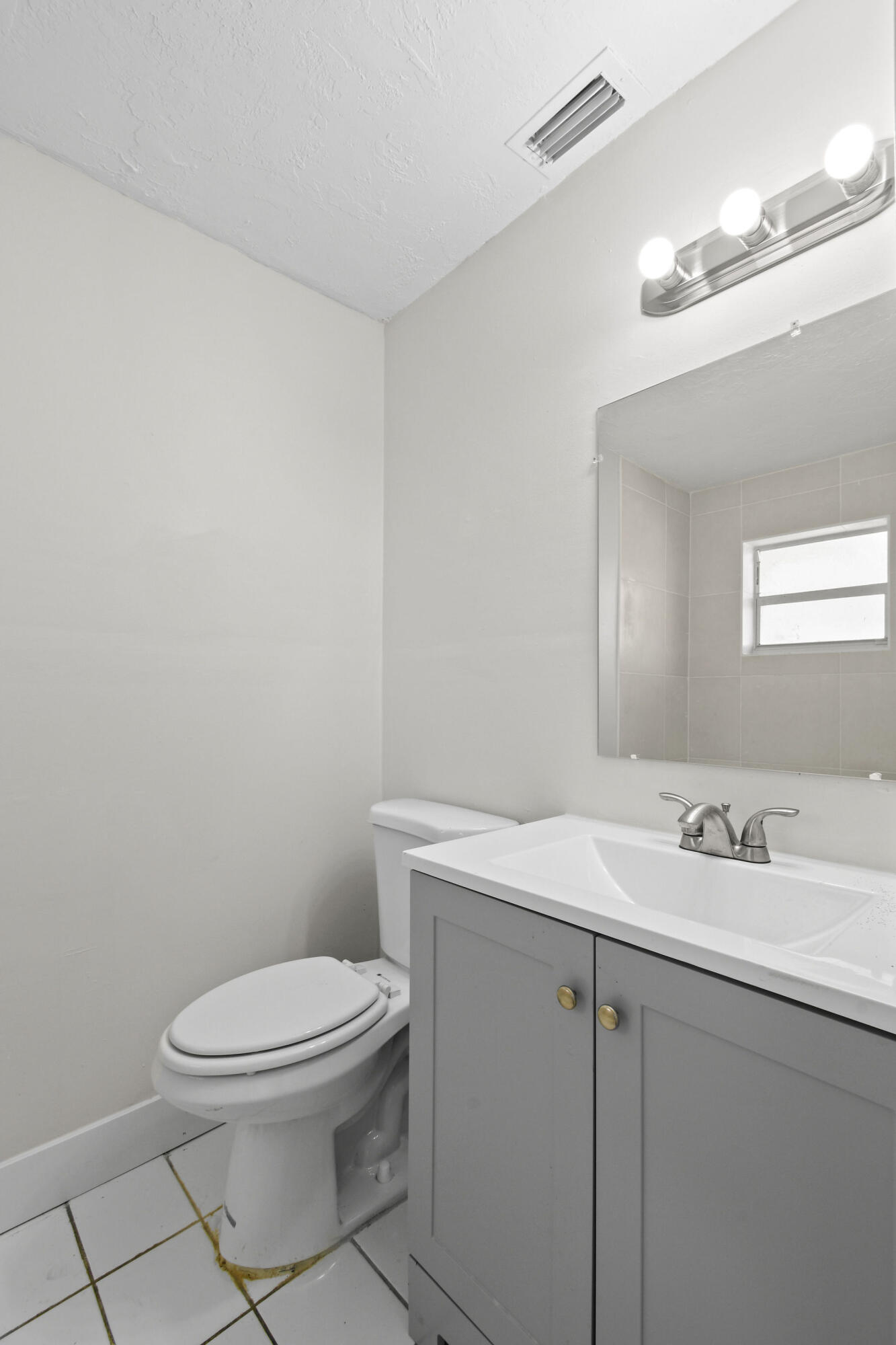 1301 West 25th Street Riviera Beach, FL 33404 - Photo 17 of 34 a bathroom with a sink a toilet and mirror