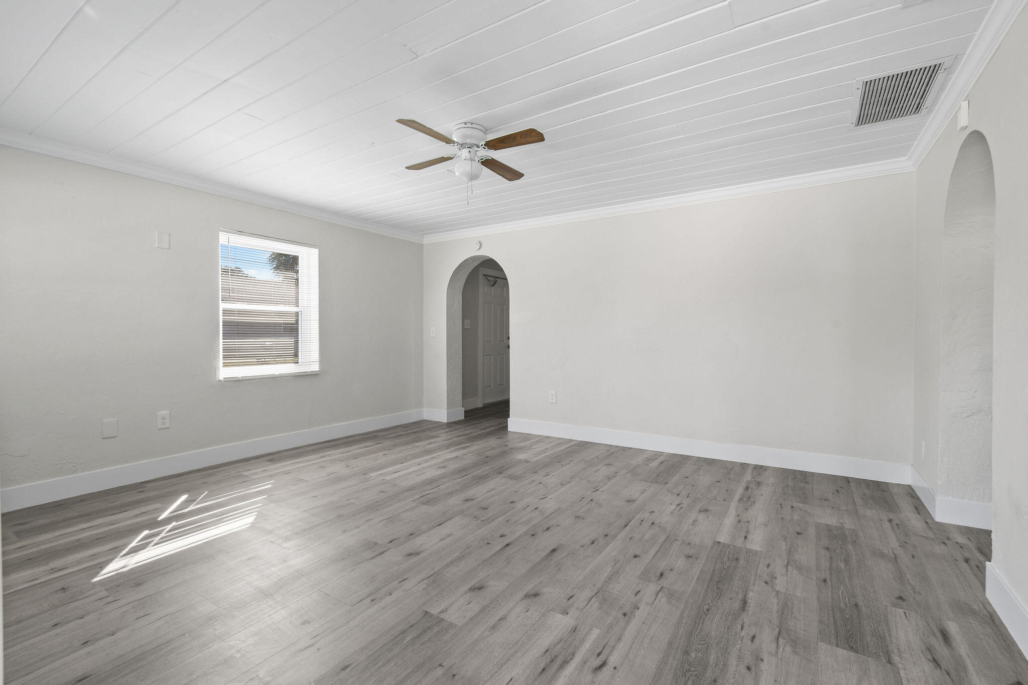 1301 West 25th Street Riviera Beach, FL 33404 - Photo 2 of 34 a view of empty room with wooden floor and fan