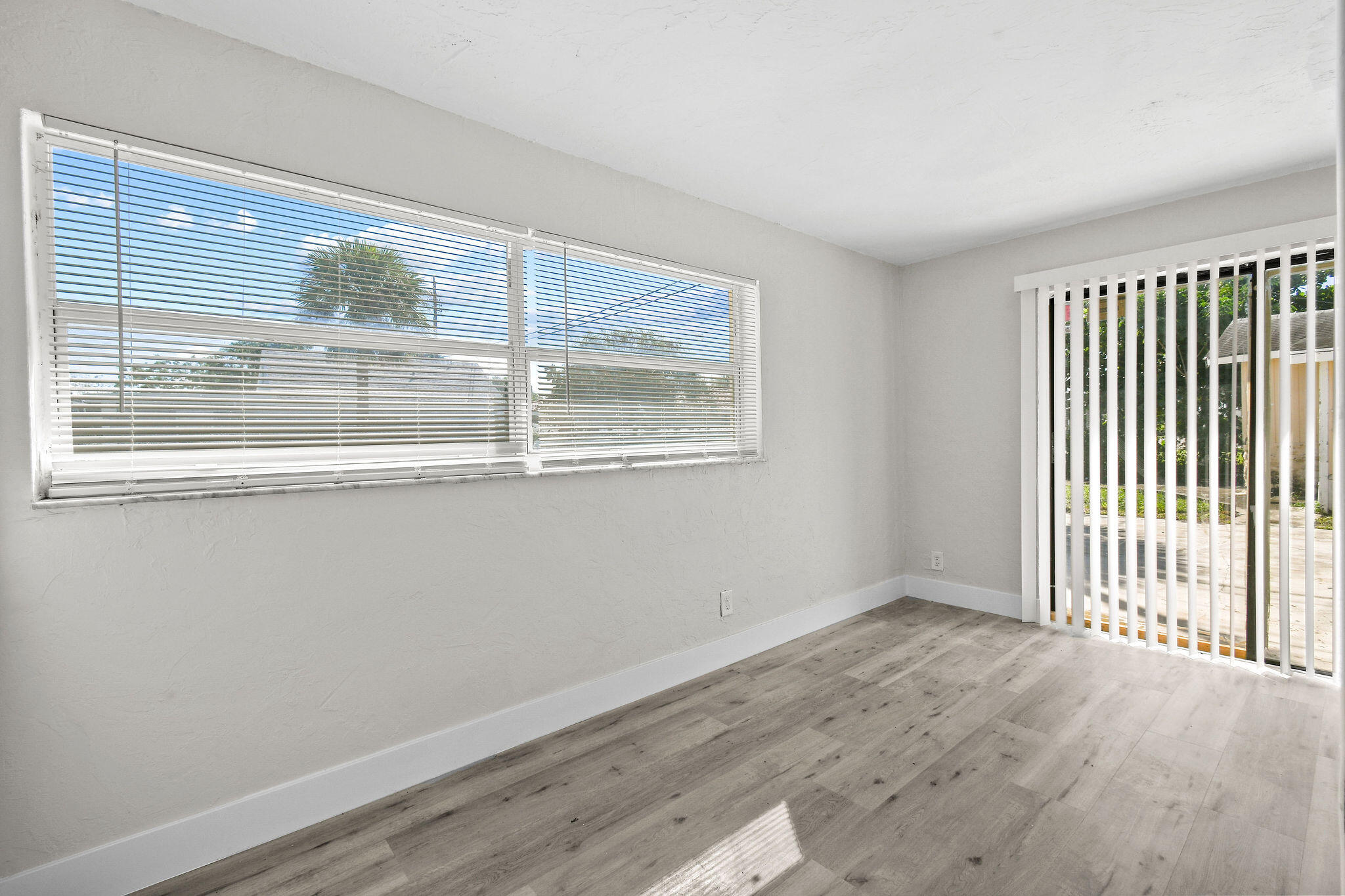 1301 West 25th Street Riviera Beach, FL 33404 - Photo 21 of 34 a view of an empty room with wooden floor and a window