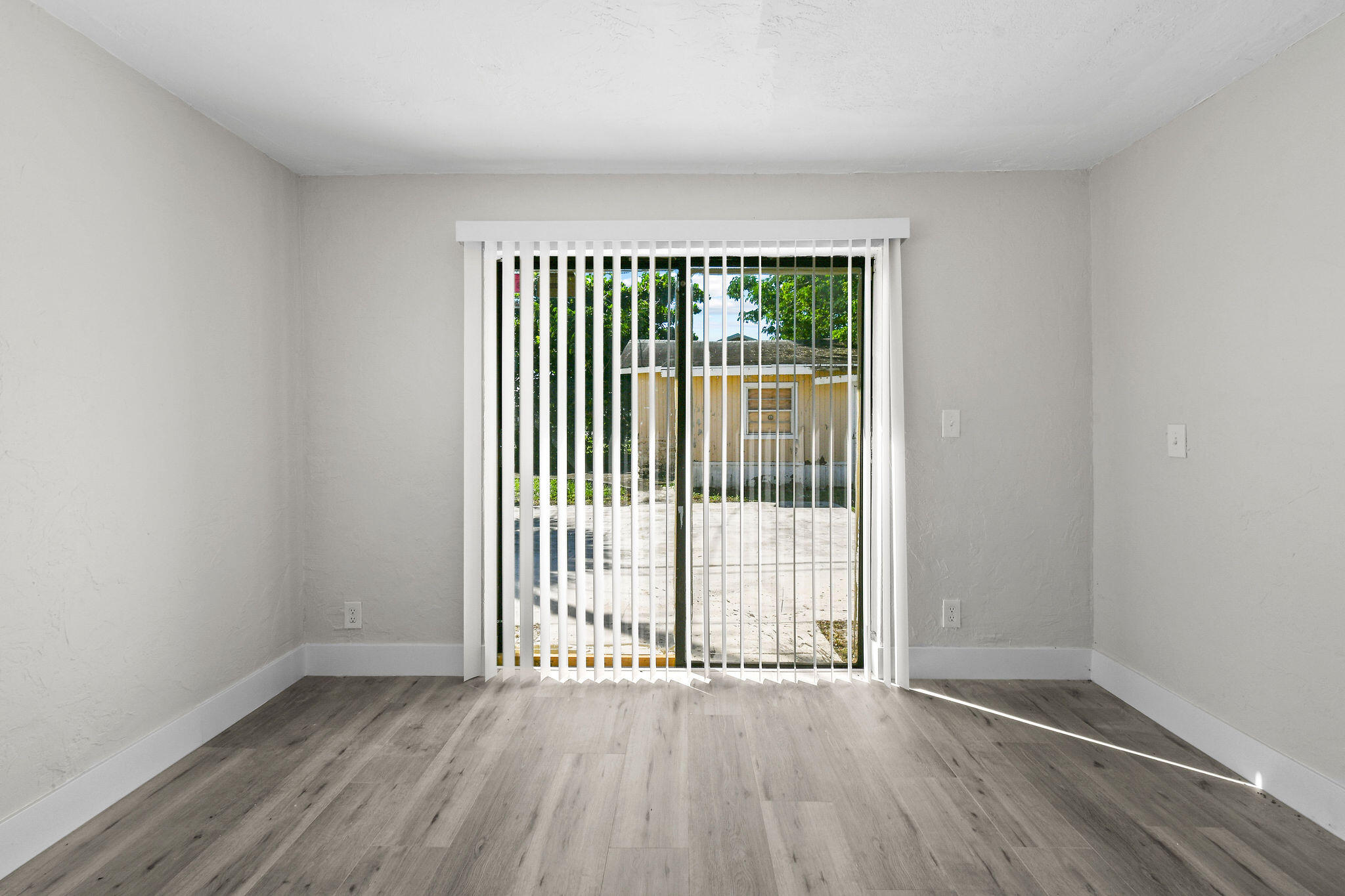 1301 West 25th Street Riviera Beach, FL 33404 - Photo 23 of 34 an empty room with wooden floor and windows