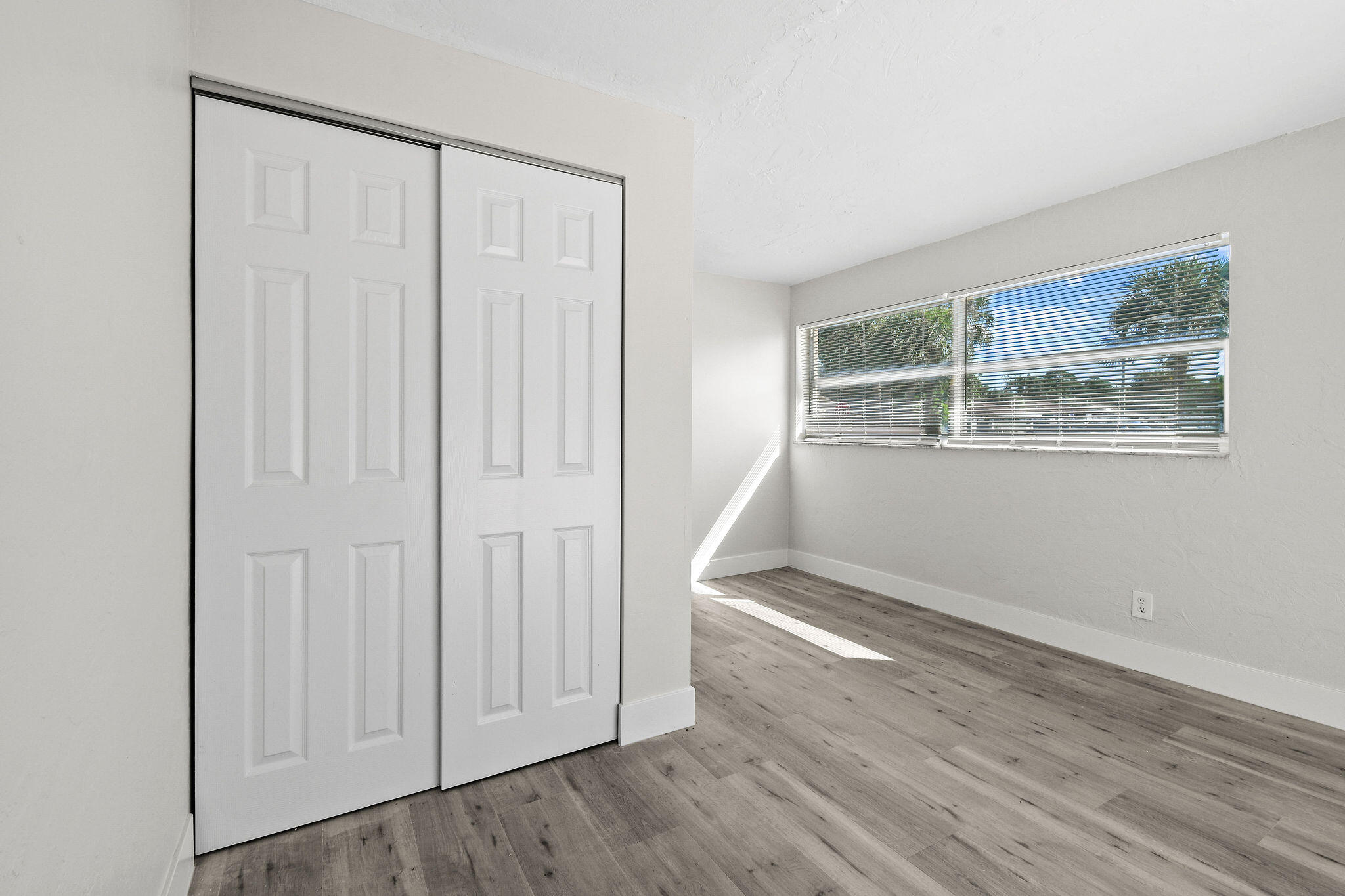 1301 West 25th Street Riviera Beach, FL 33404 - Photo 25 of 34 an empty room with wooden floor and windows
