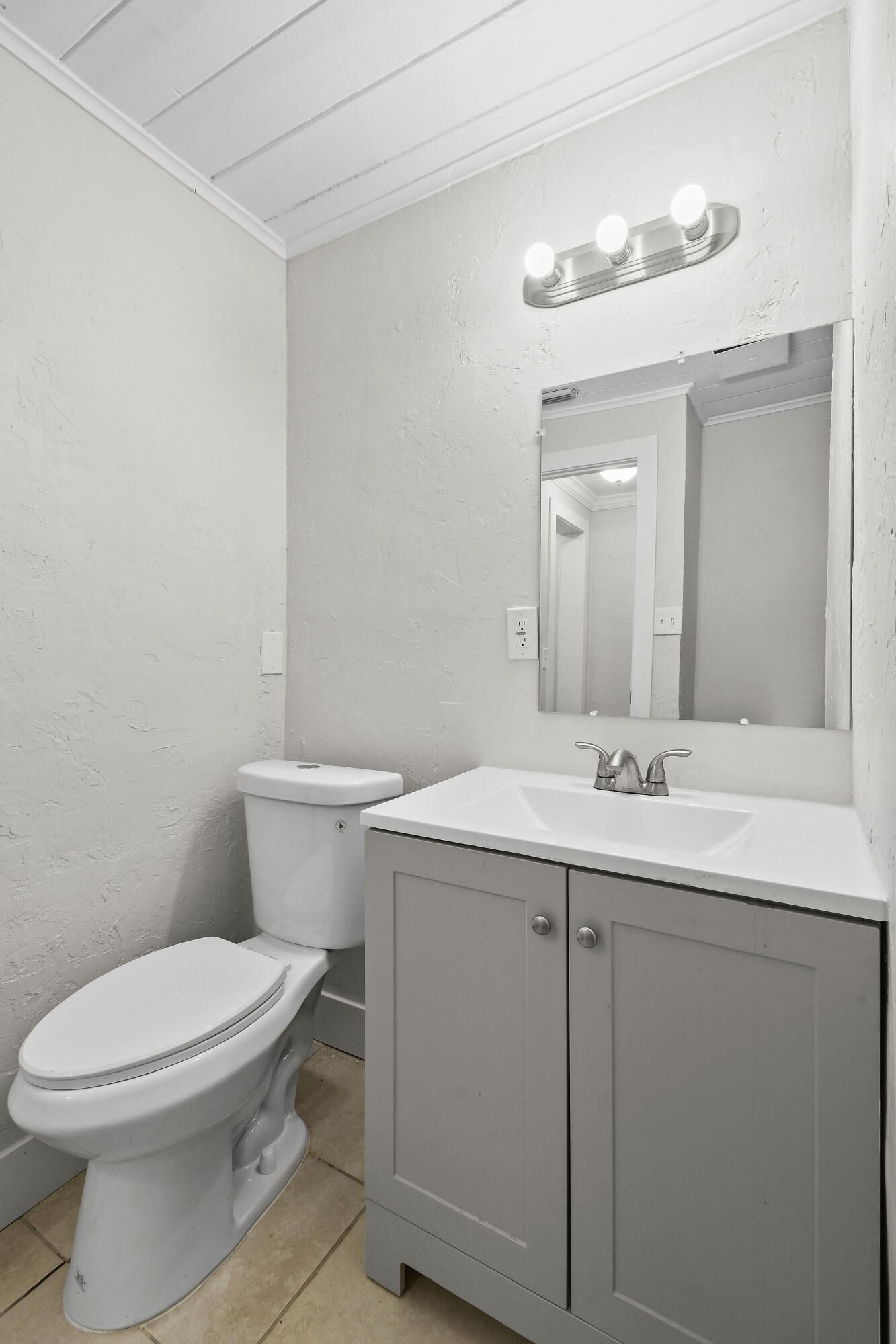 1301 West 25th Street Riviera Beach, FL 33404 - Photo 30 of 34 a bathroom with a toilet a sink and mirror