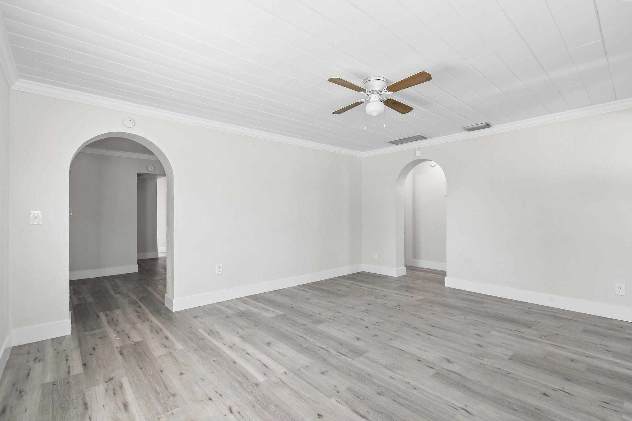 1301 West 25th Street Riviera Beach, FL 33404 - Photo 3 of 34 an empty room with wooden floor a ceiling fan and white walls