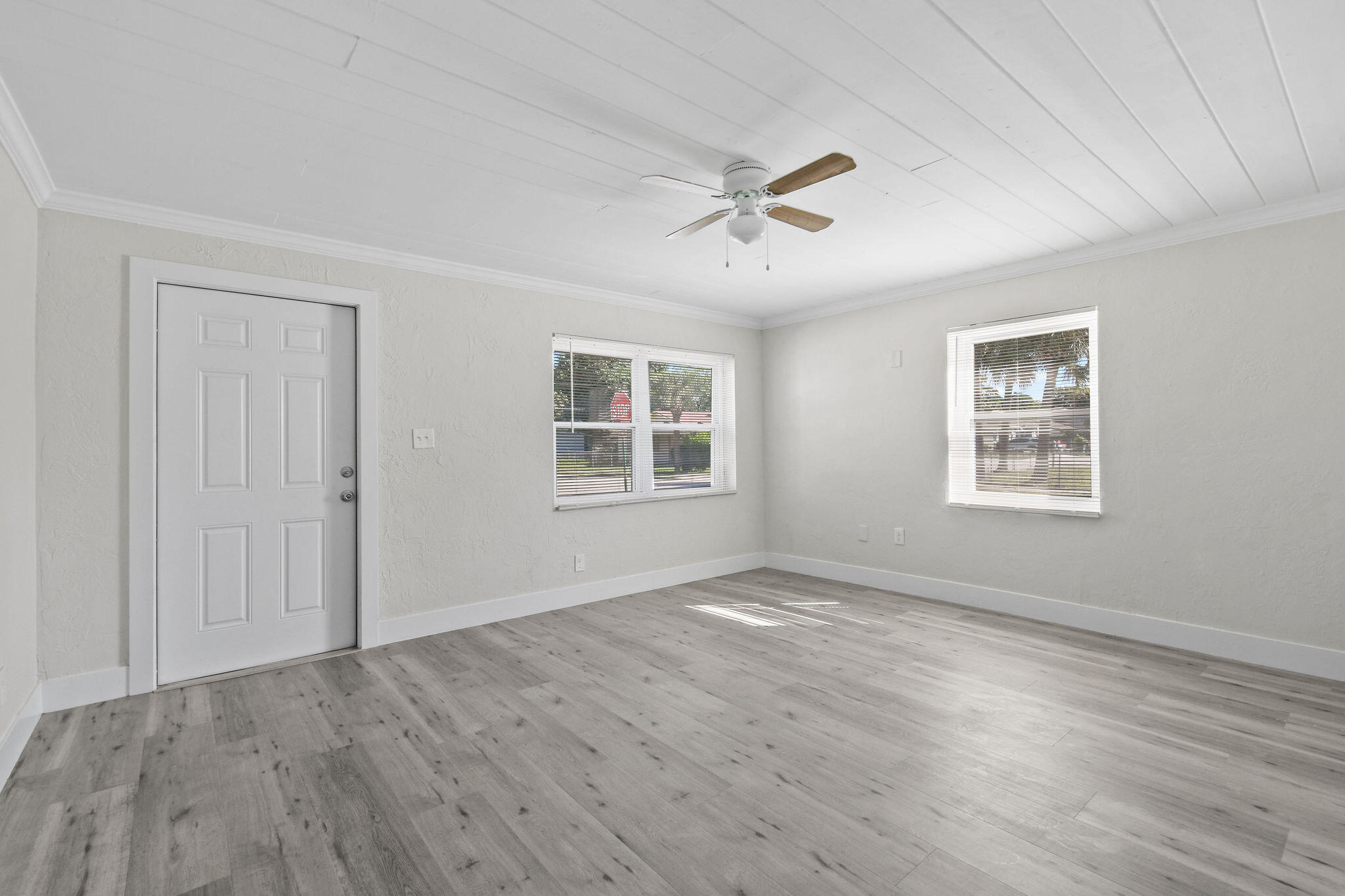 1301 West 25th Street Riviera Beach, FL 33404 - Photo 4 of 34 a view of empty room with wooden floor and fan