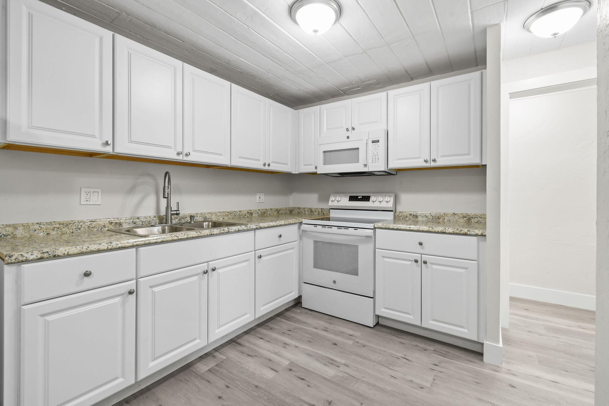1301 West 25th Street Riviera Beach, FL 33404 - Photo 10 of 34 a kitchen with granite countertop white cabinets and white appliances