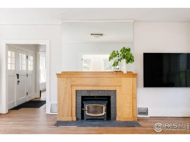 a living room with a fireplace and wooden floor