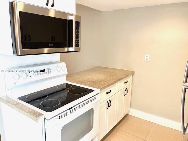 777 Southwest 9th Avenue, Unit 413 Miami, FL 33130 - Photo 11 of 36 a kitchen with a stove and a microwave