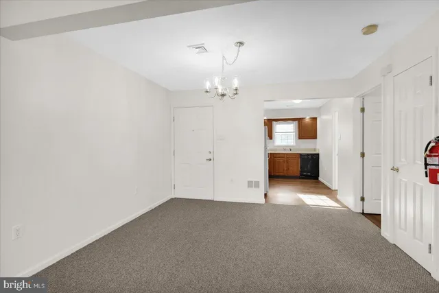 an empty room with a fireplace and a chandelier