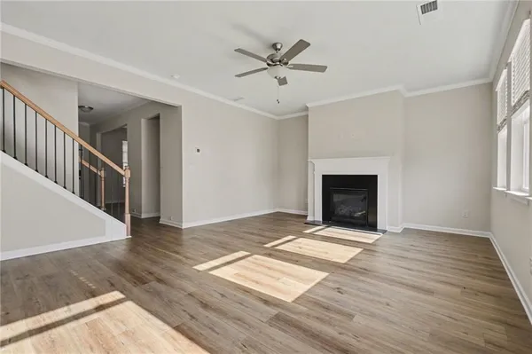 wooden floor in an empty room with a fireplace and a window