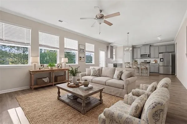 a living room with furniture and a large window with kitchen view
