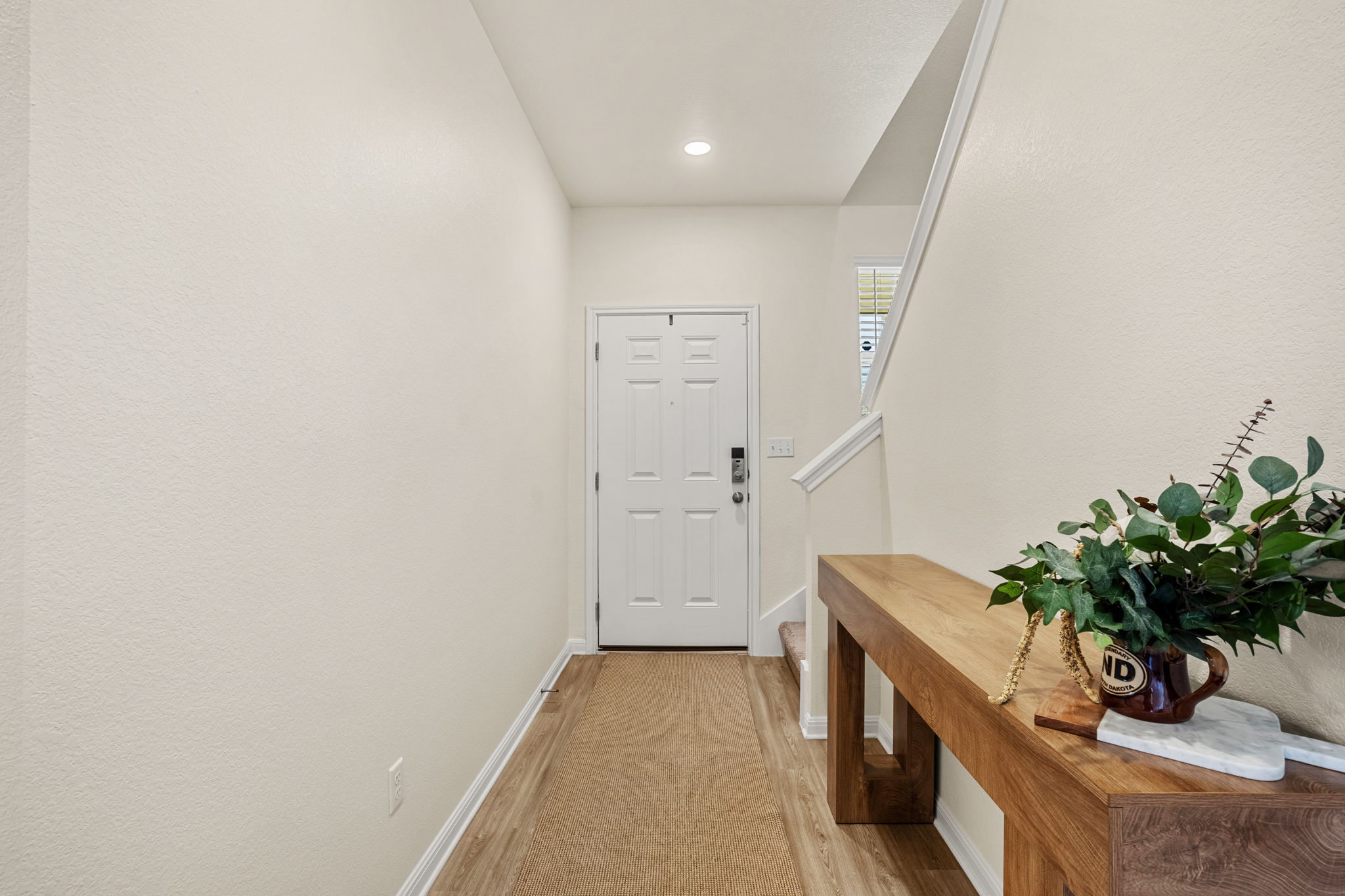 148 Hidalgo Lane Elgin, TX 78621 - Photo 7 of 38 Enter into a welcoming hallway, featuring warm wood-look flooring leading to the main entrance.