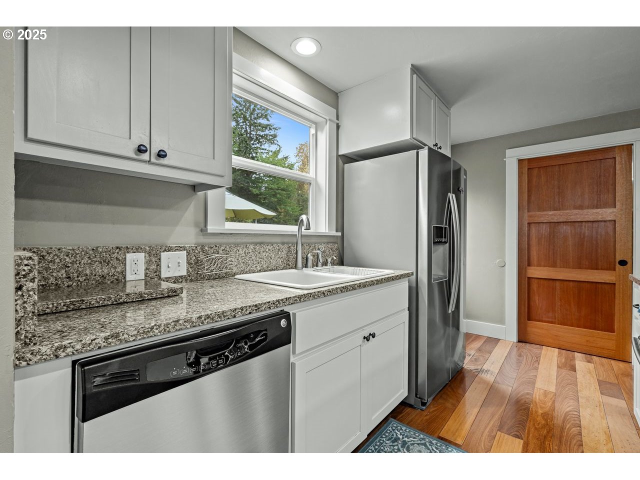 24781 Dunham Road Veneta, OR 97487 - Photo 10 of 22 a kitchen with stainless steel appliances granite countertop a refrigerator a sink dishwasher and wooden cabinets with wooden floor