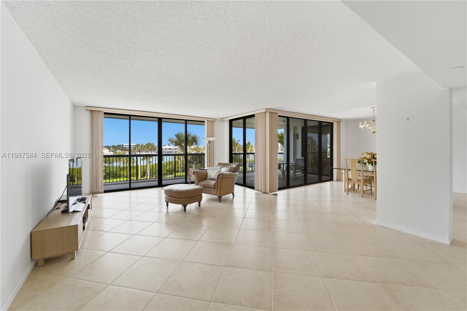 19670 South Beach Road, Unit B323 Tequesta, FL 33469 - Photo 11 of 57 a large living room with furniture and large windows