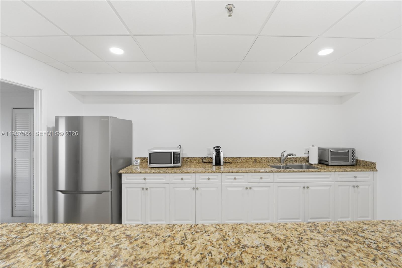 19670 South Beach Road, Unit B323 Tequesta, FL 33469 - Photo 55 of 57 a kitchen with a sink a refrigerator and a sink
