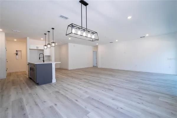 a kitchen with stainless steel appliances granite countertop a refrigerator and microwave a stove with wooden floors