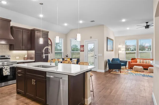 a kitchen with stainless steel appliances granite countertop a sink and a refrigerator