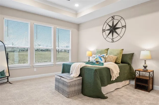 a spacious bedroom with a bed a chandelier and a large window